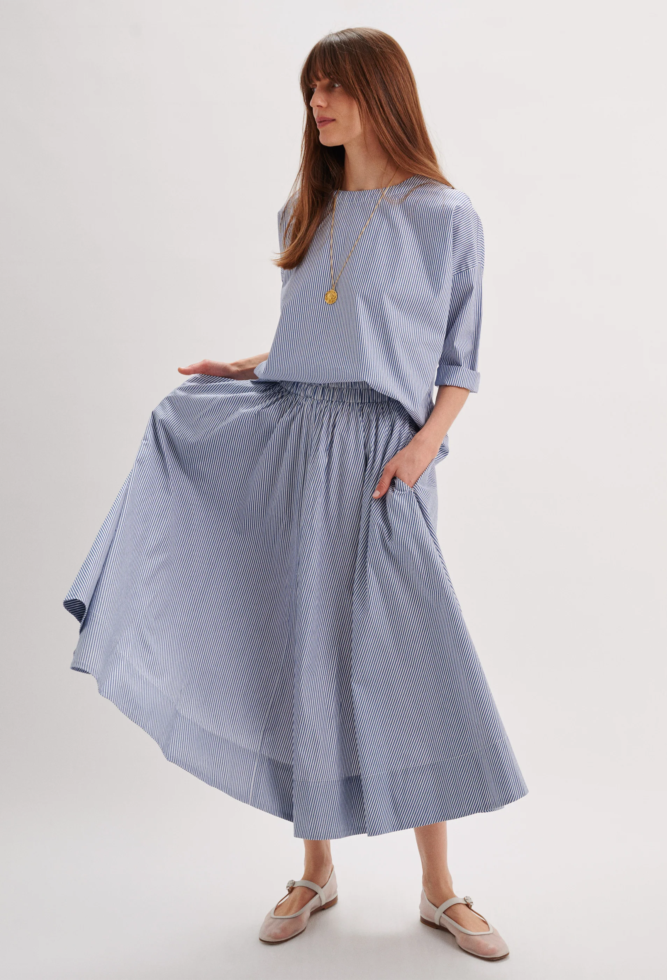 Woman wearing a light blue dress with a plain background
