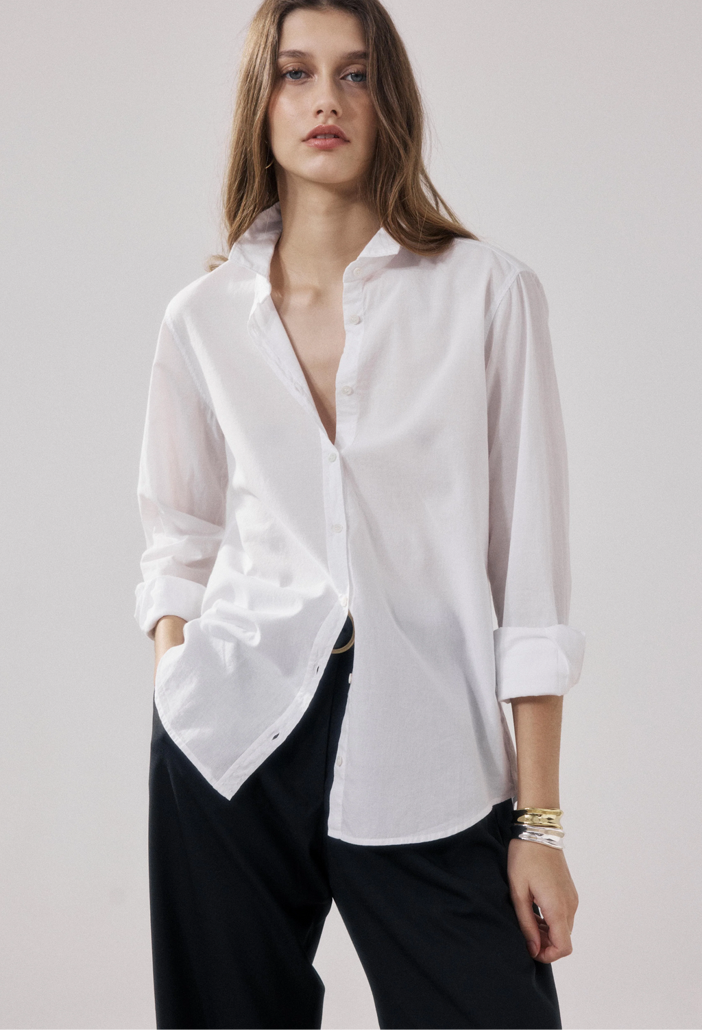 Woman wearing a white blouse with a plain background