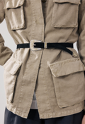 Beige jacket with multiple pockets and a black belt with a silver buckle on a light gray background