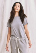 Woman wearing a gray outfit with a plain background