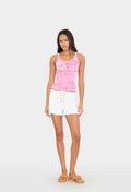 Woman wearing a pink tank top and white shorts on a white background