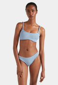 Woman wearing a light blue bikini on a white background