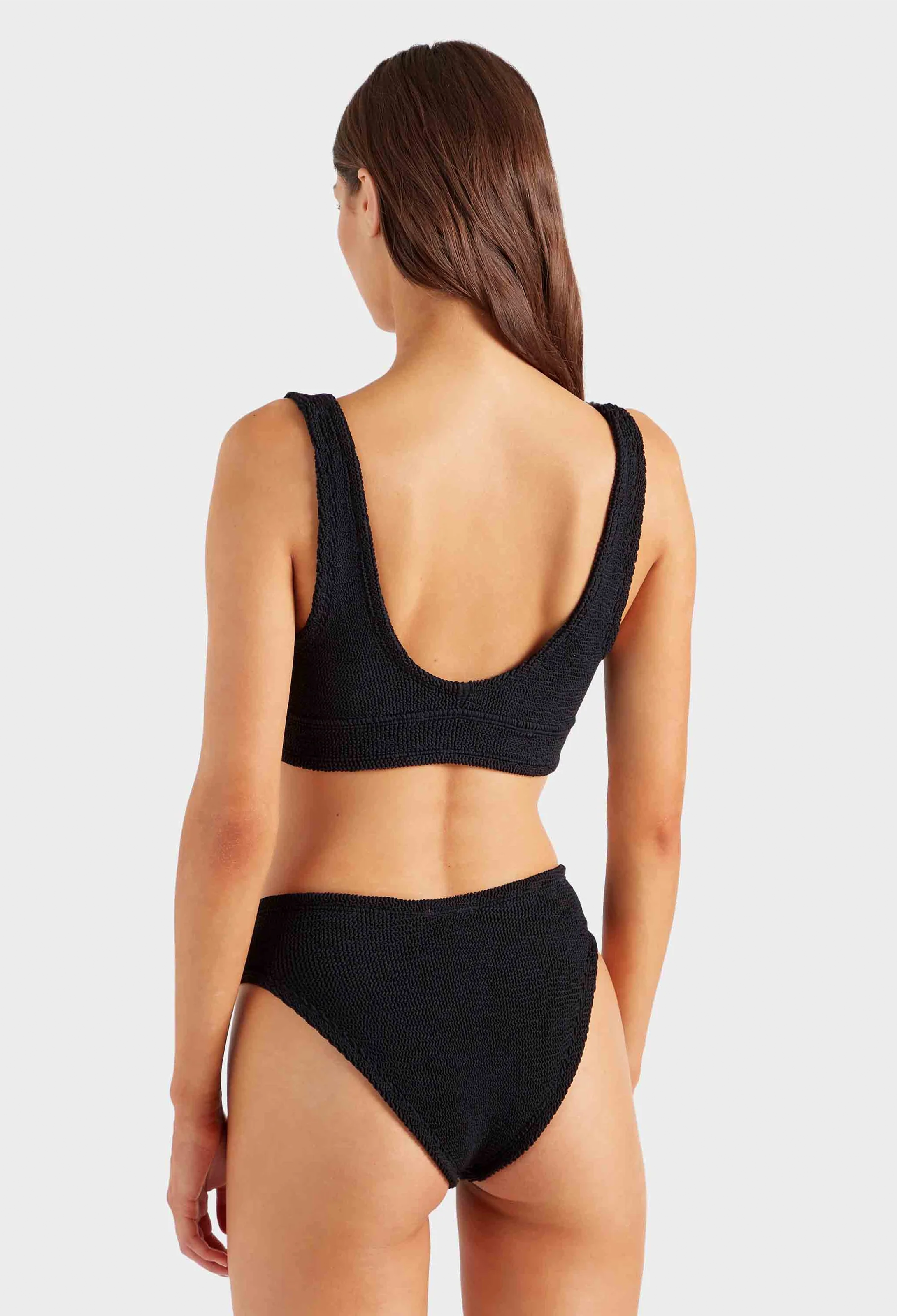 Woman wearing a black bikini on a white background