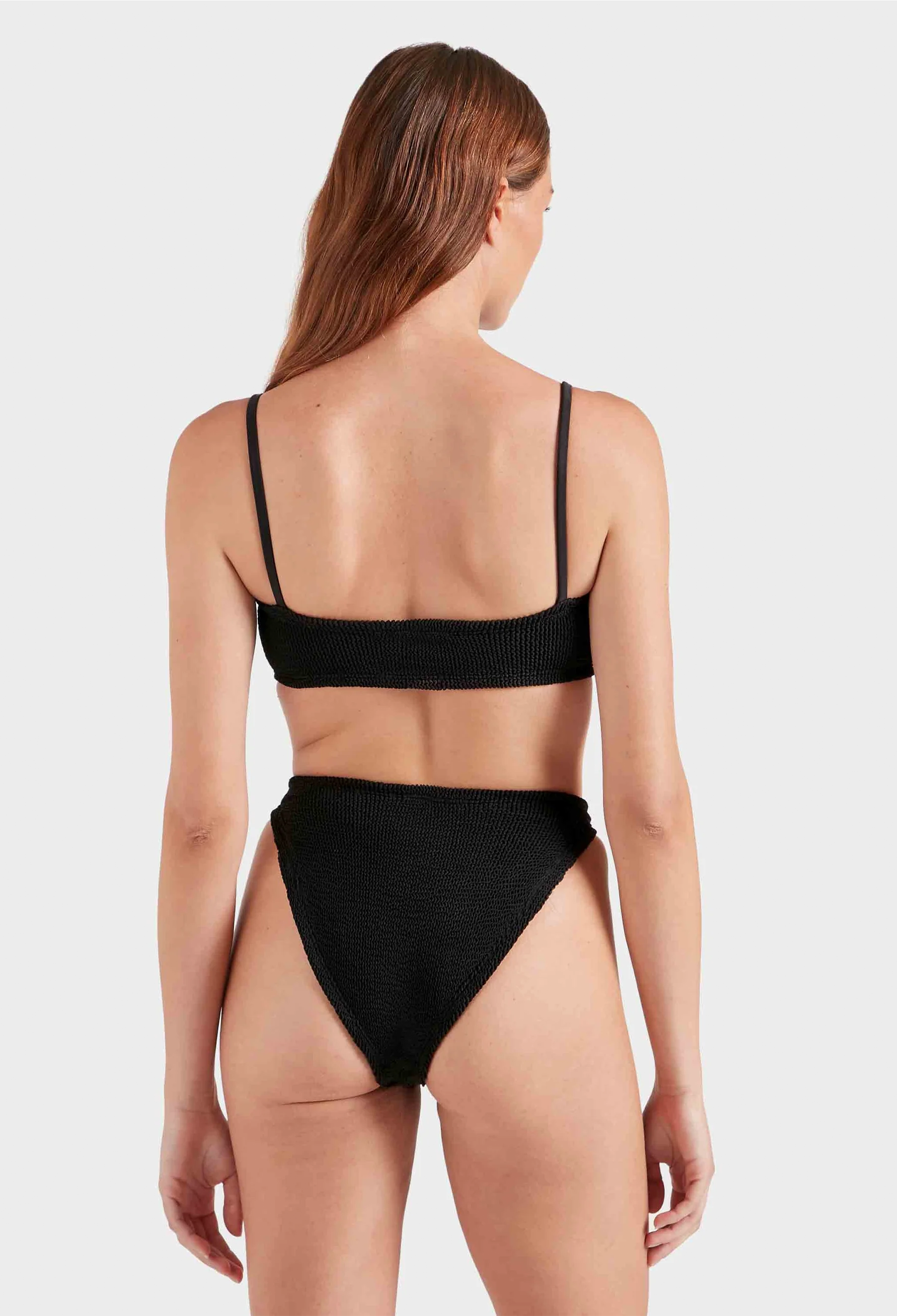 Woman wearing a black bikini on a white background