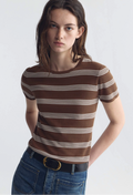 Woman wearing a brown and white striped shirt with blue jeans on a white background