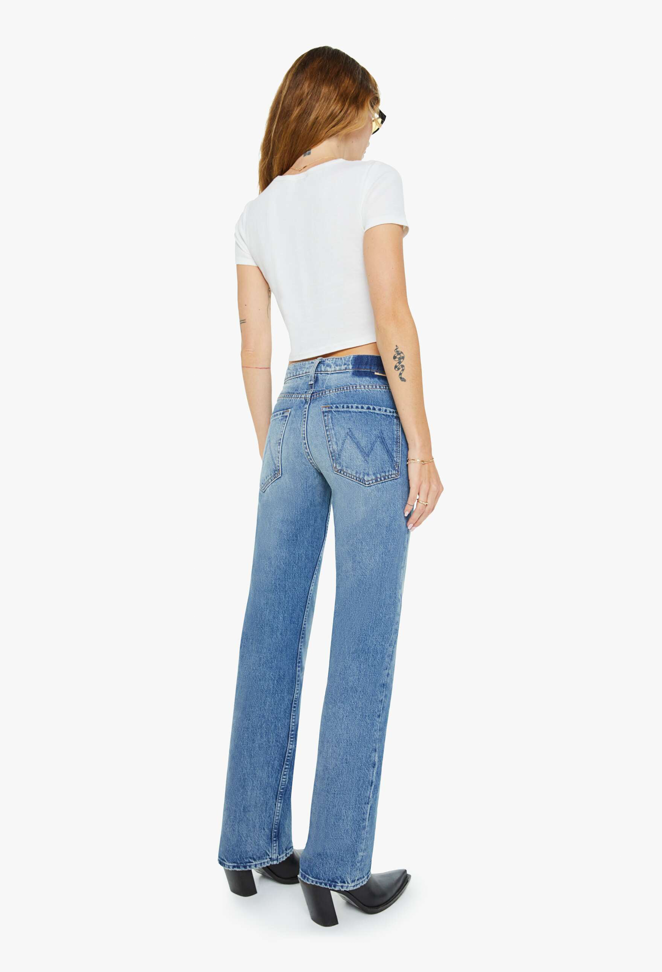 Person wearing blue jeans and a white top on a white background