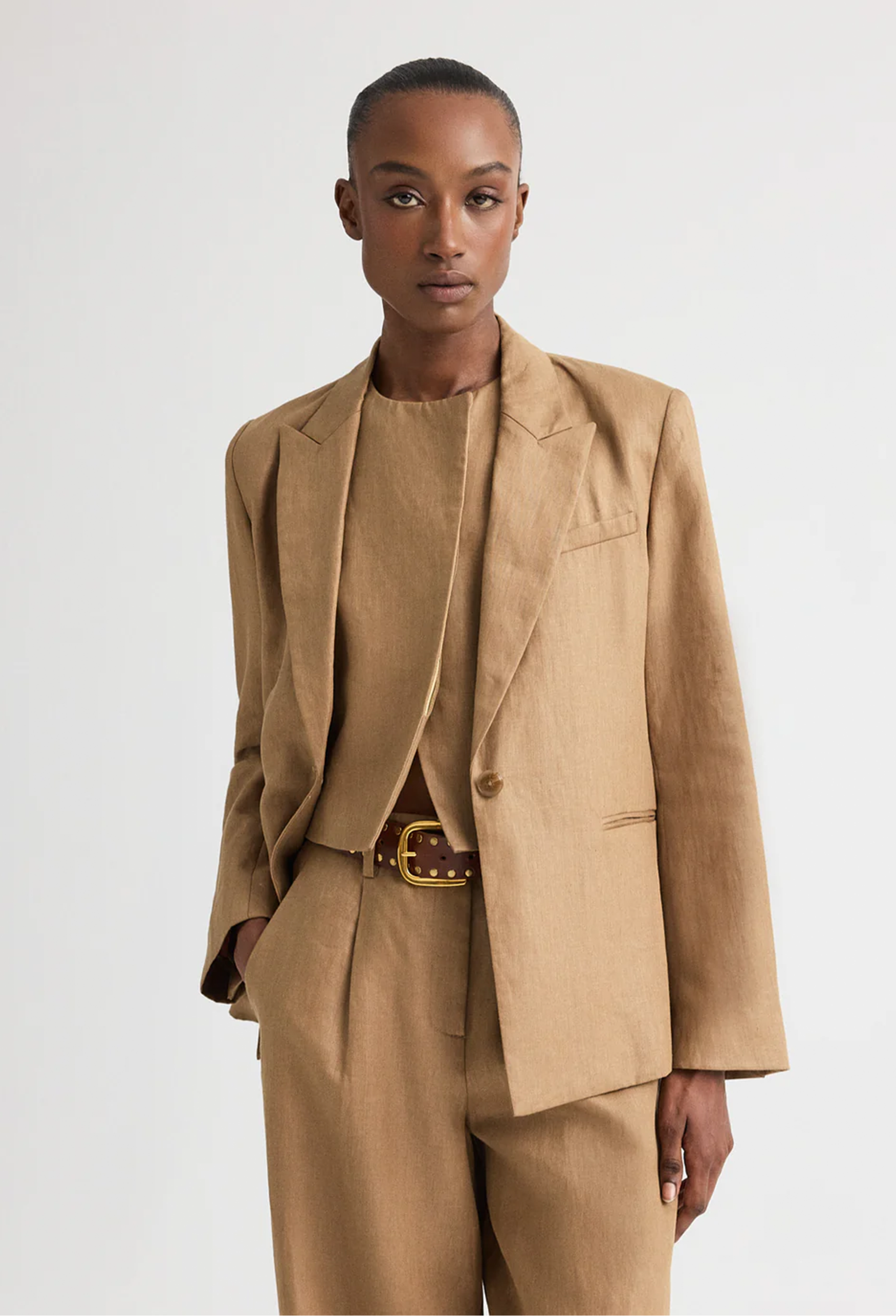 Person wearing a beige suit with a white background