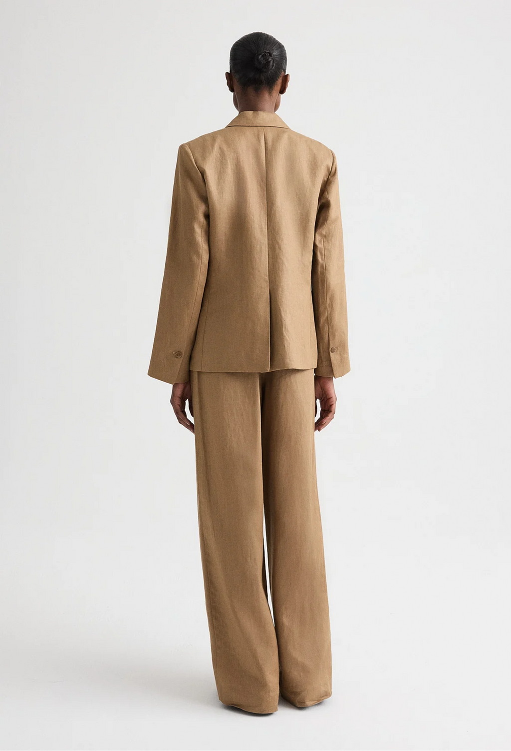 Person wearing a beige suit on a white background