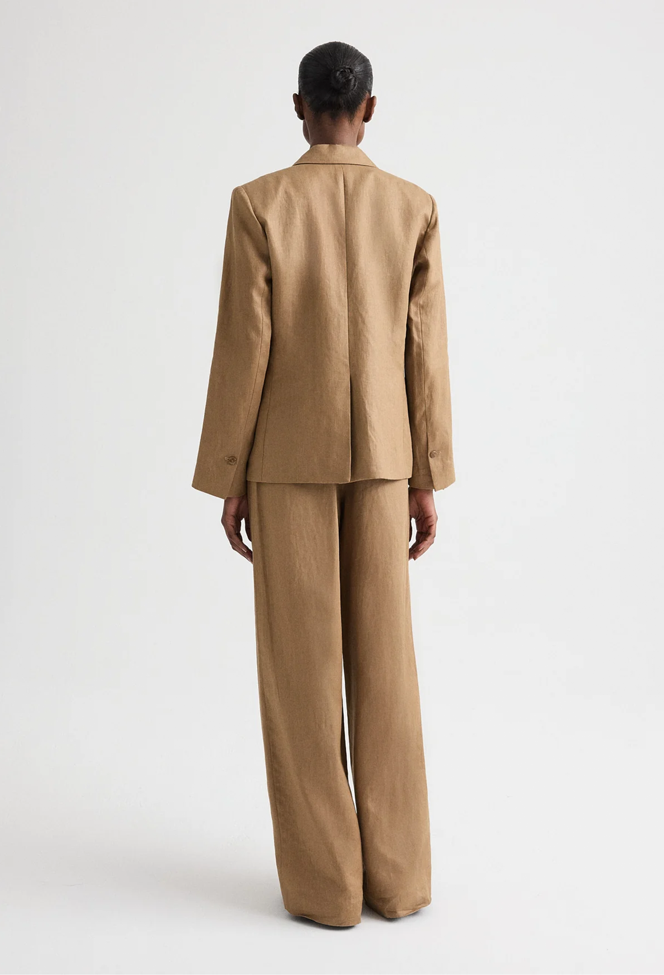 Person wearing a beige suit on a white background