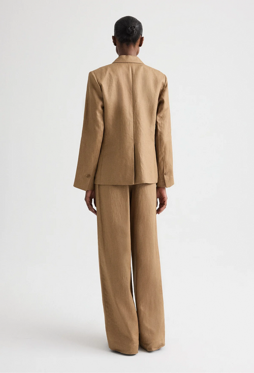Person wearing a beige suit on a white background
