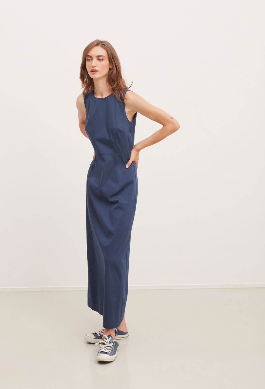 Woman wearing a blue jumpsuit against a white background