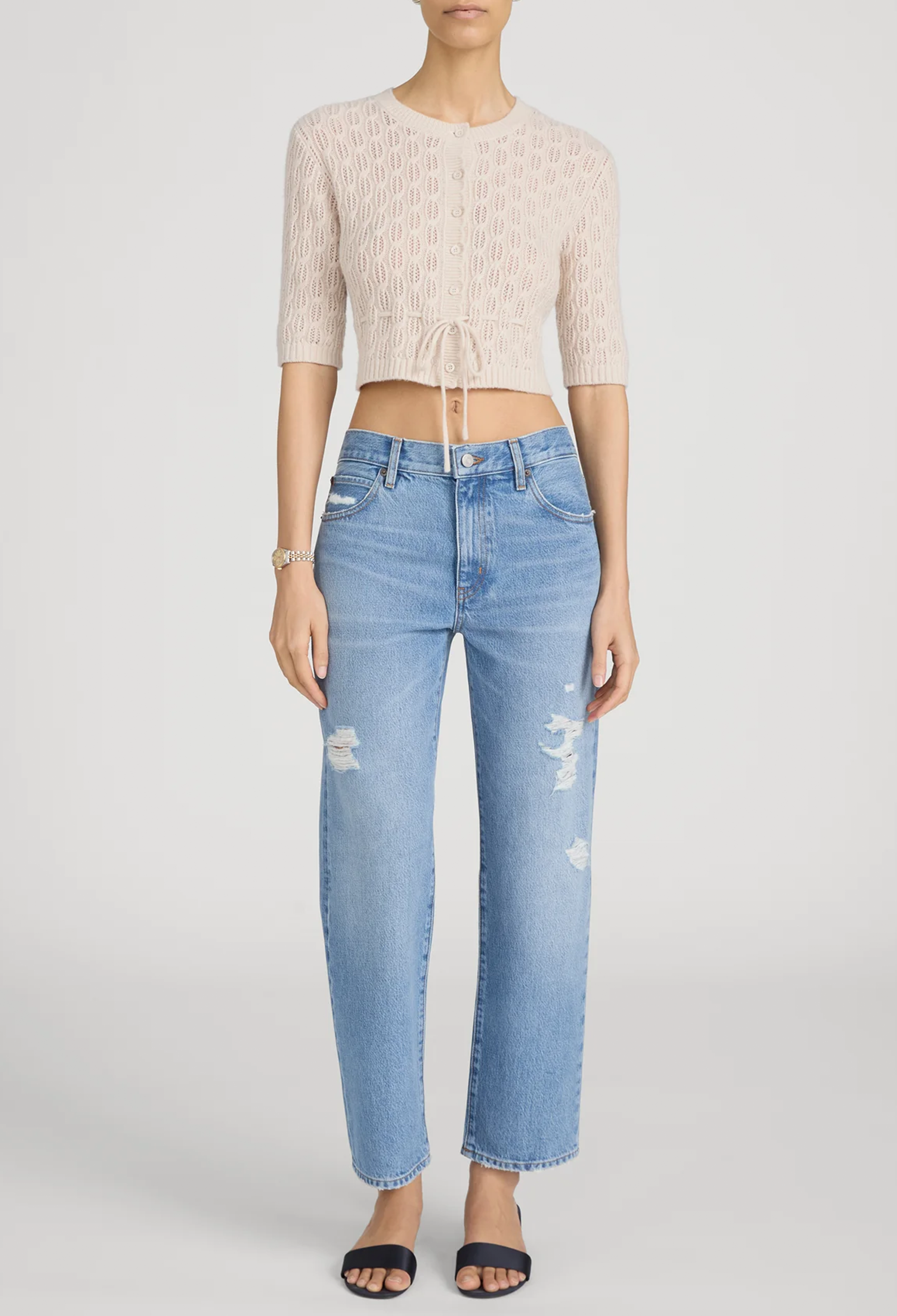 model wearing blue jeans against a white background