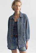 model wearing an oversized blue and white striped jacket on a white background