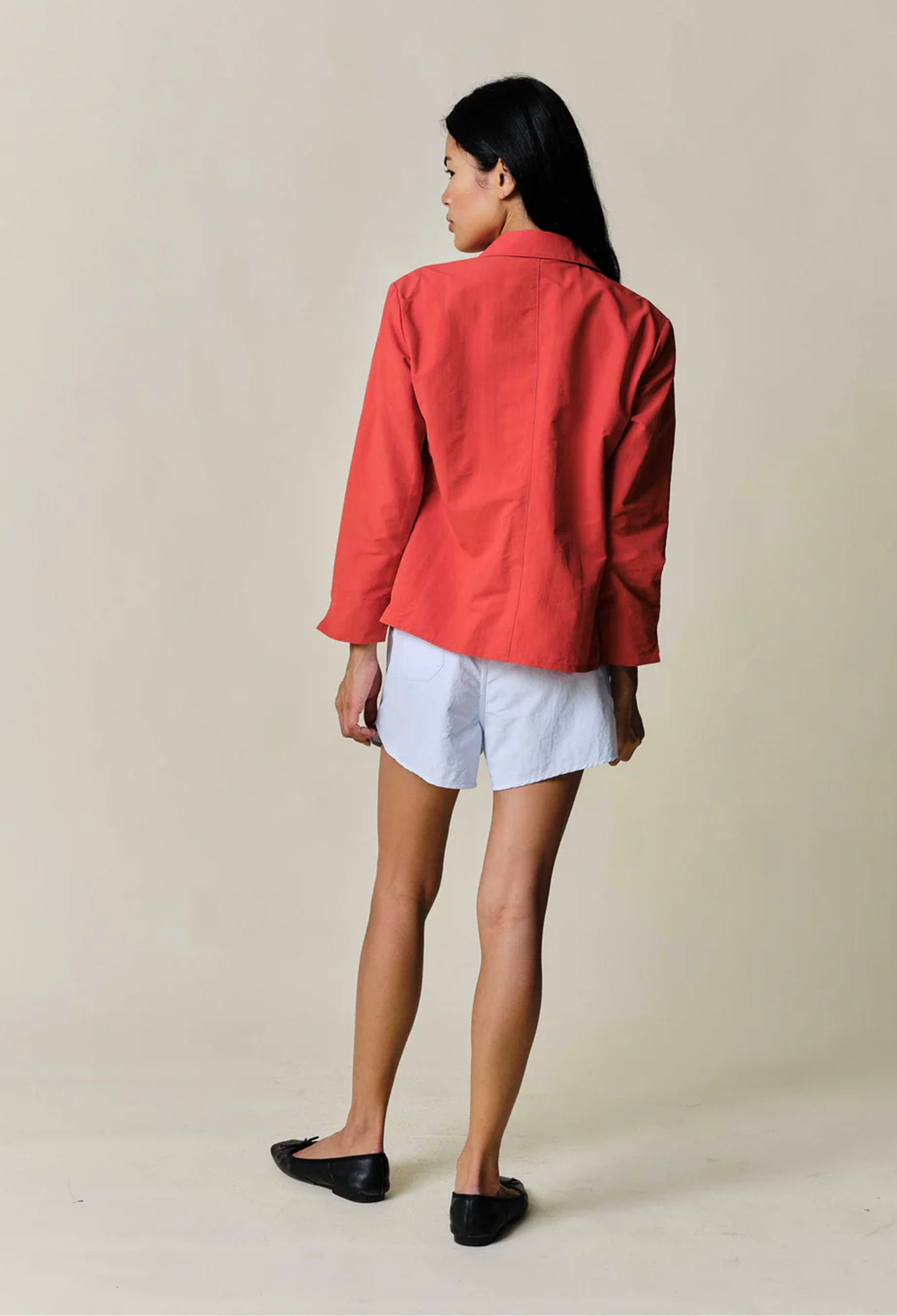 model wearing light blue drawstring shorts on a beige background