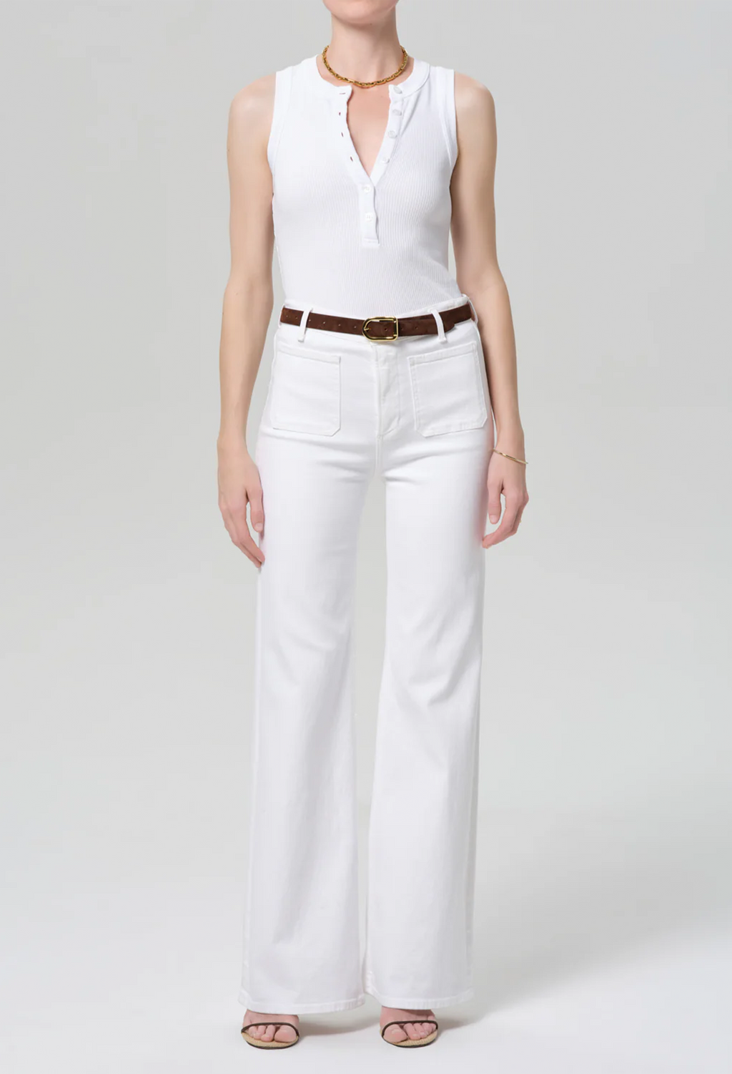 model wearing a white top and white jeans on a white background
