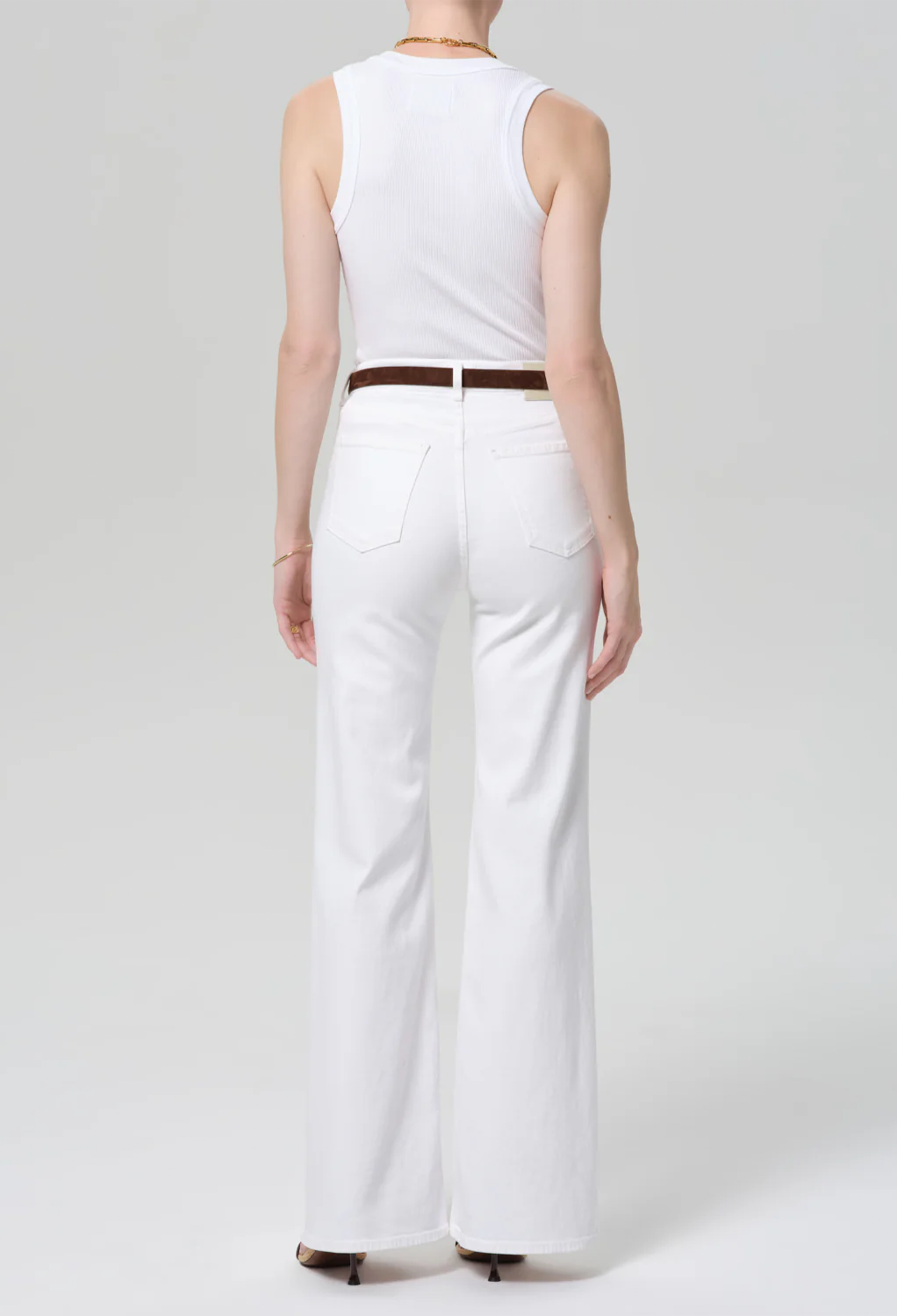 model wearing a white top and white jeans on a white background