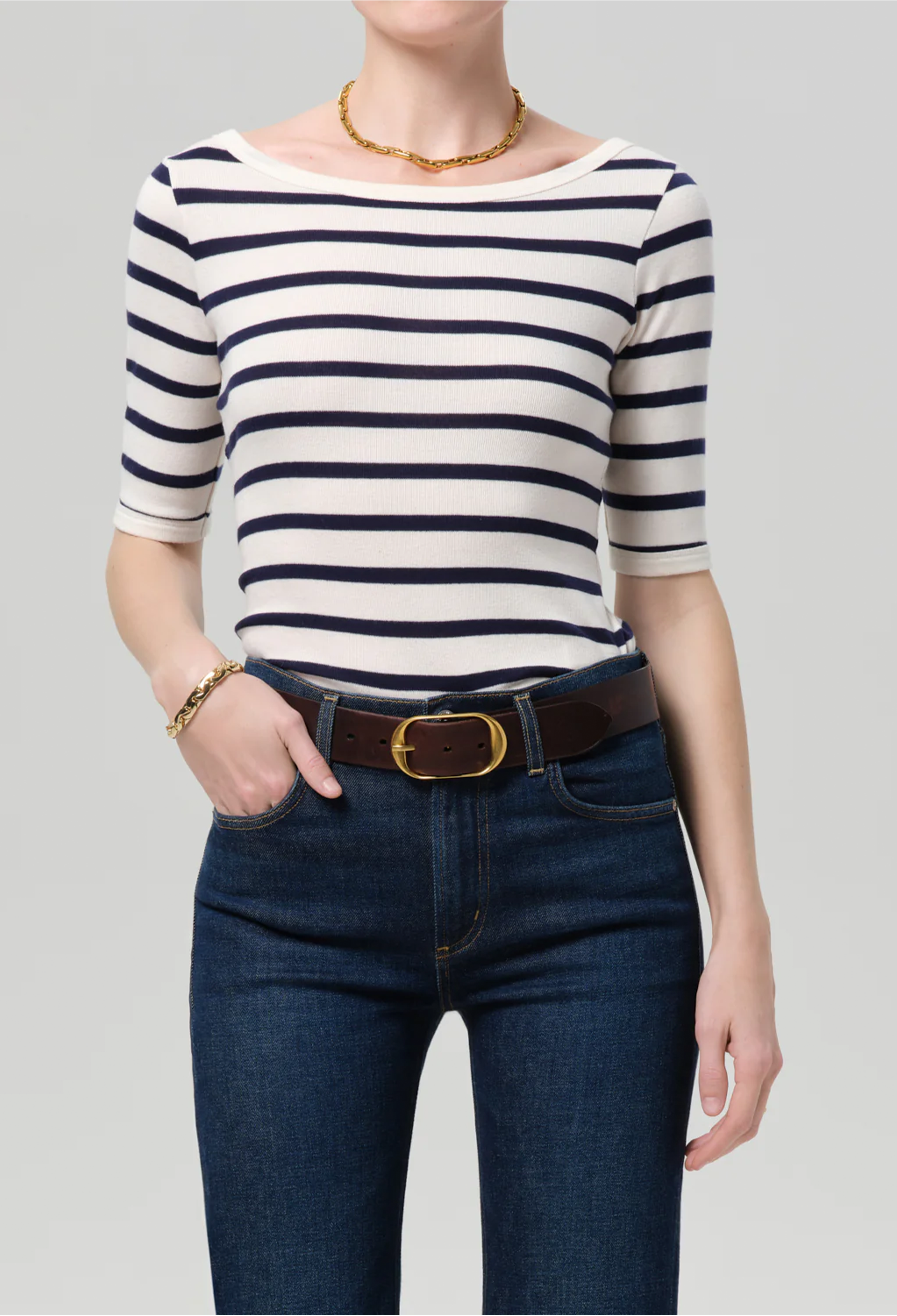 model wearing jeans and a blue and white striped boatneck tee
