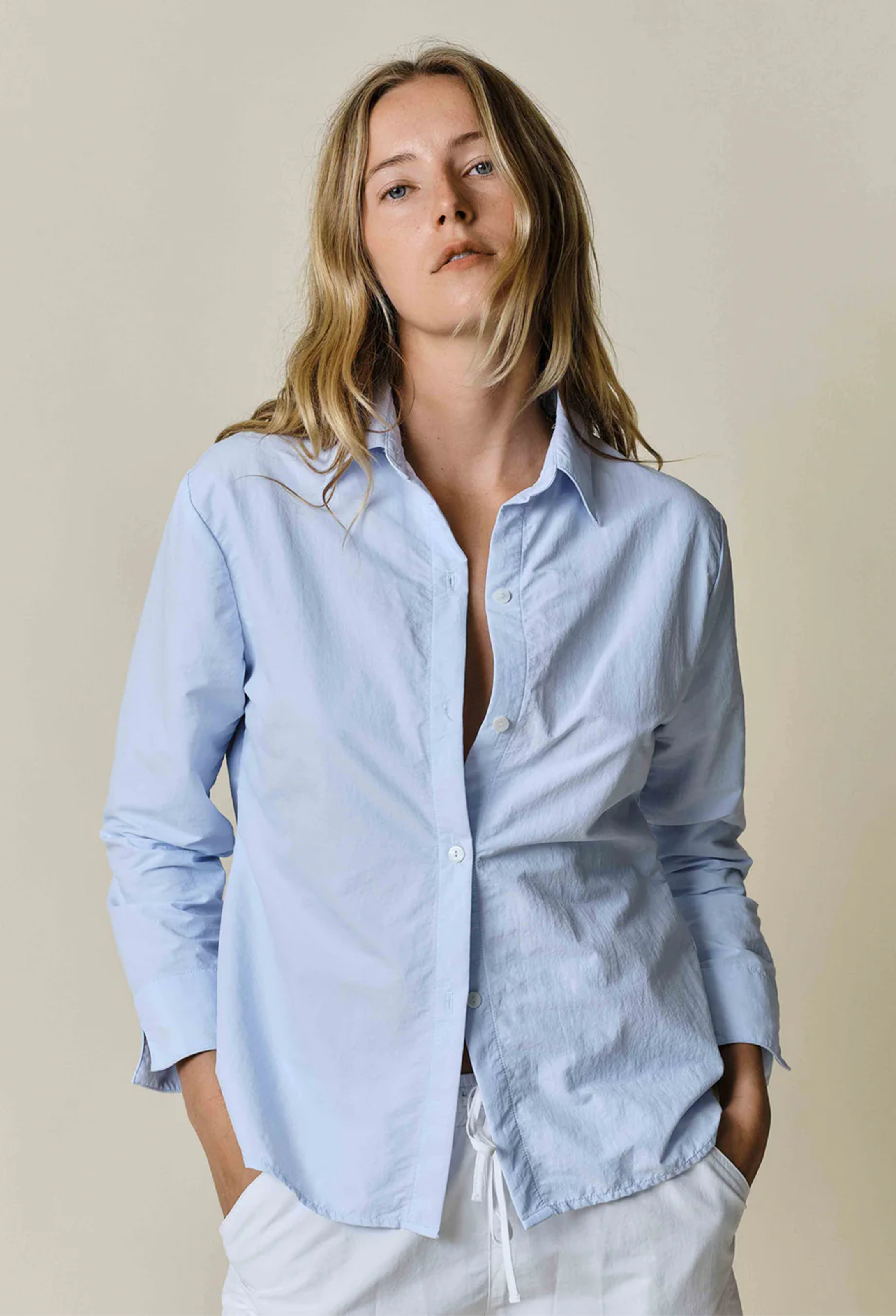model wearing blue button up shirt on a white background