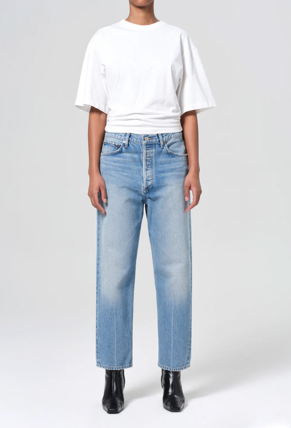 model wearing a white tee and jeans on a white background