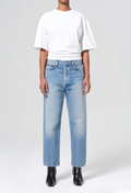 model wearing a white tee and jeans on a white background