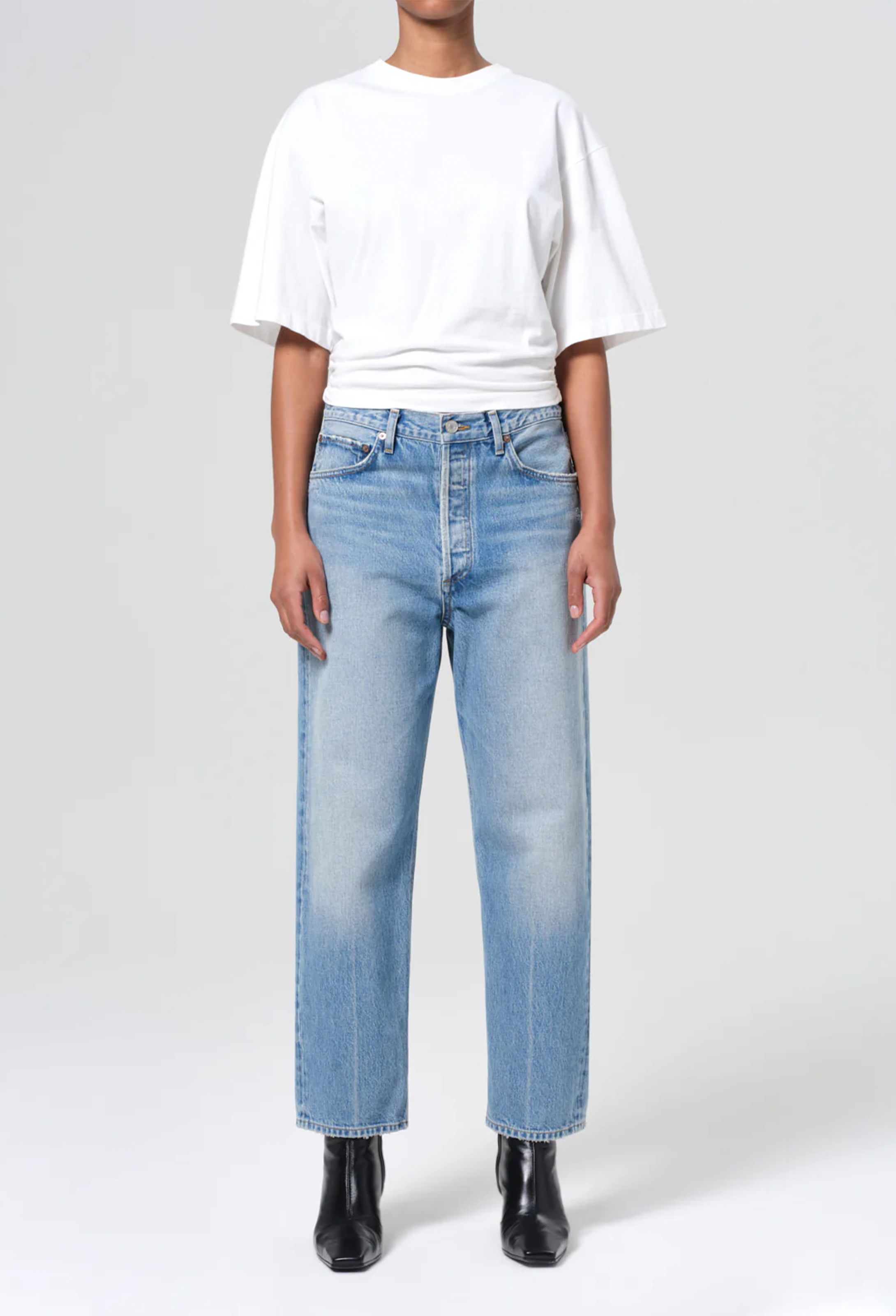 model wearing a white tee and jeans on a white background