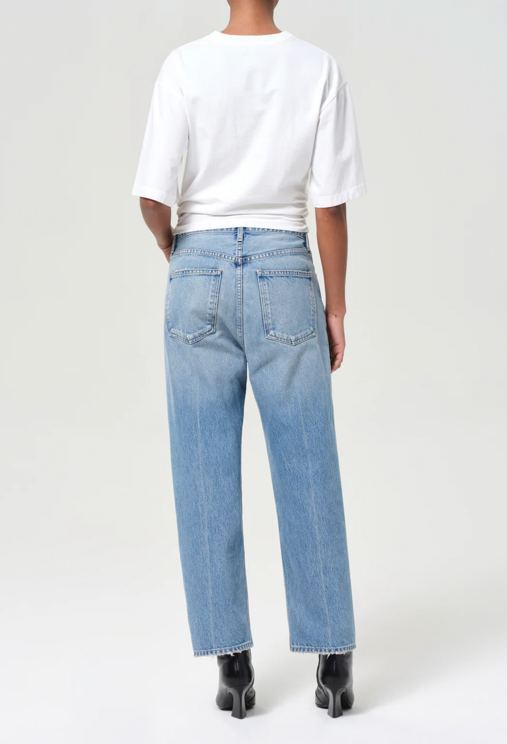 model wearing a white tee and jeans on a white background