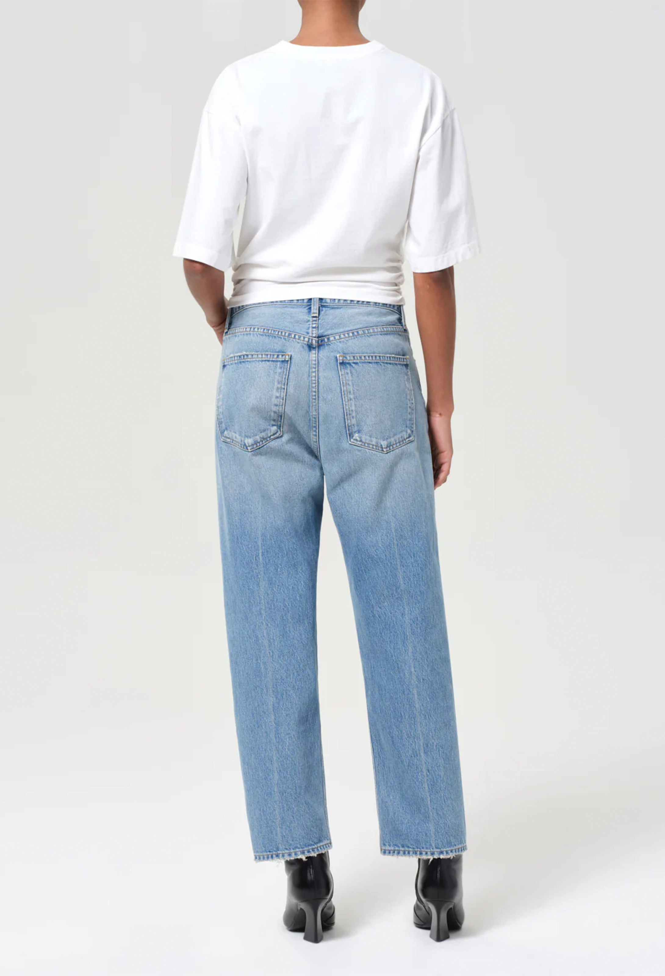 model wearing a white tee and jeans on a white background