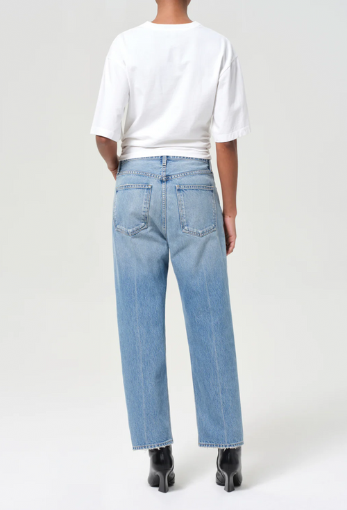model wearing a white tee and jeans on a white background