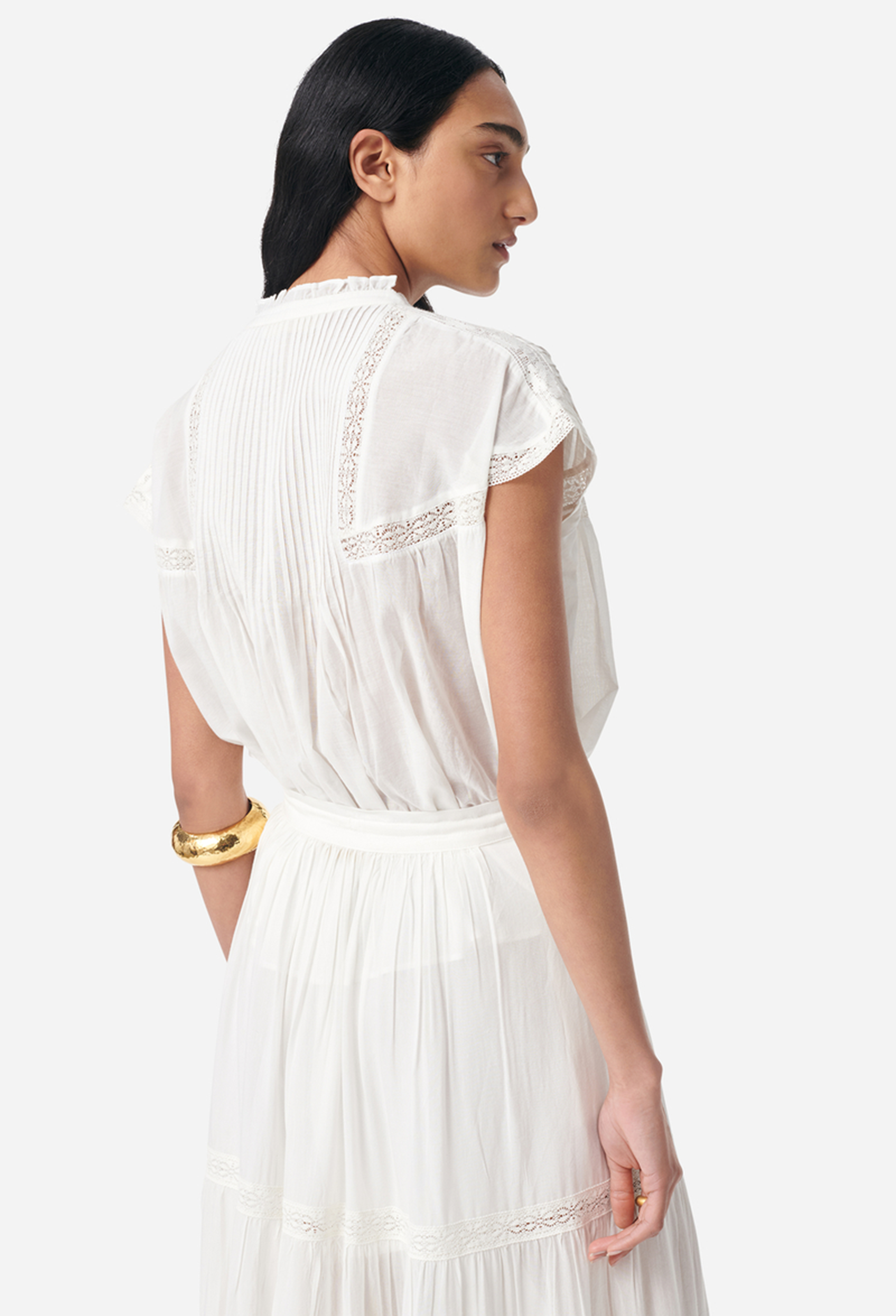 model wearing a white skirt and short sleeve white blouse on a white background