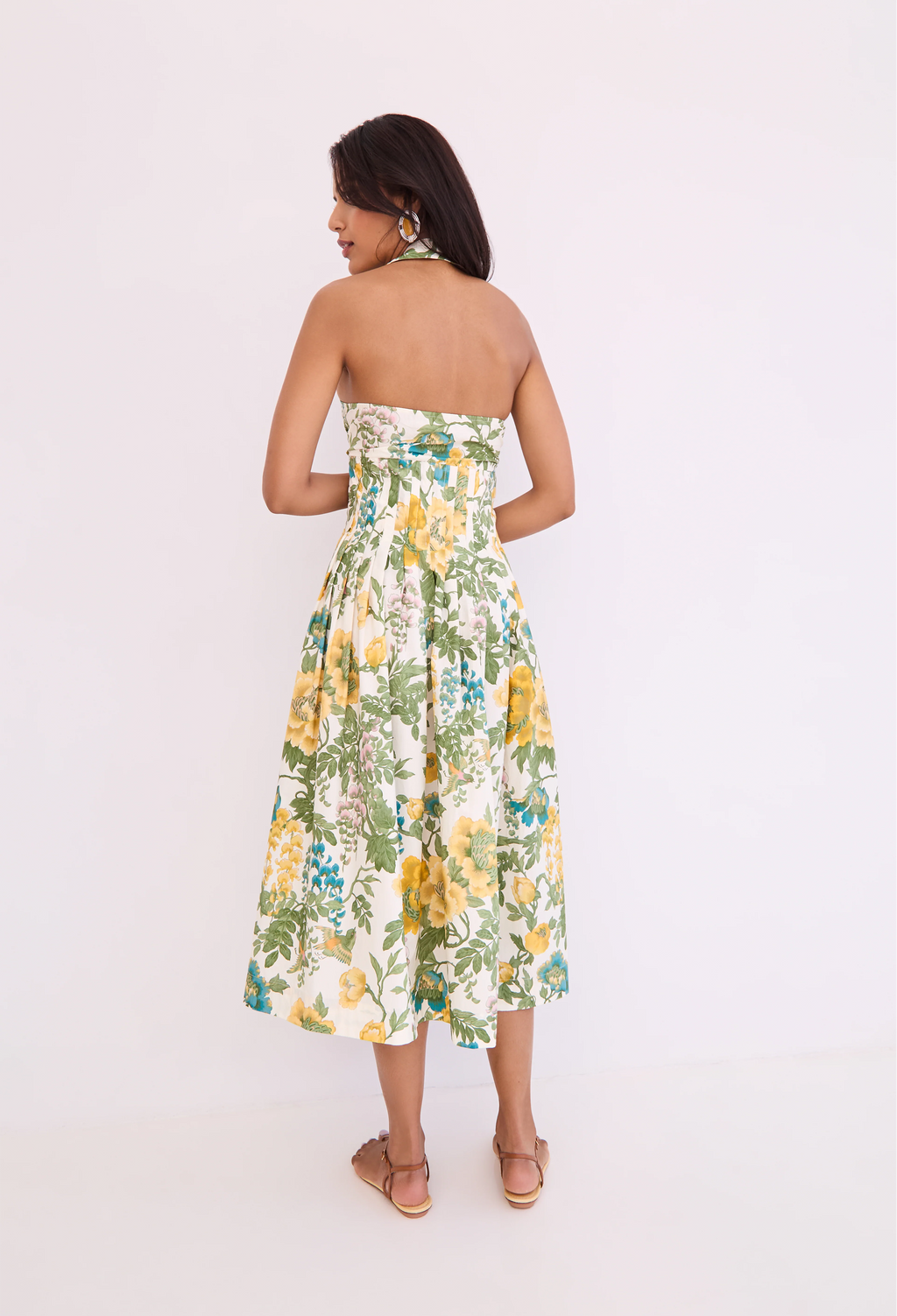 Woman wearing a strapless floral dress on a white background