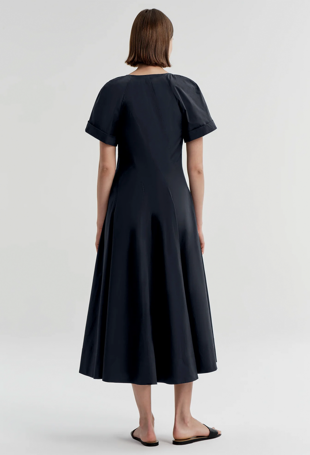 Woman wearing a navy dress on a white background