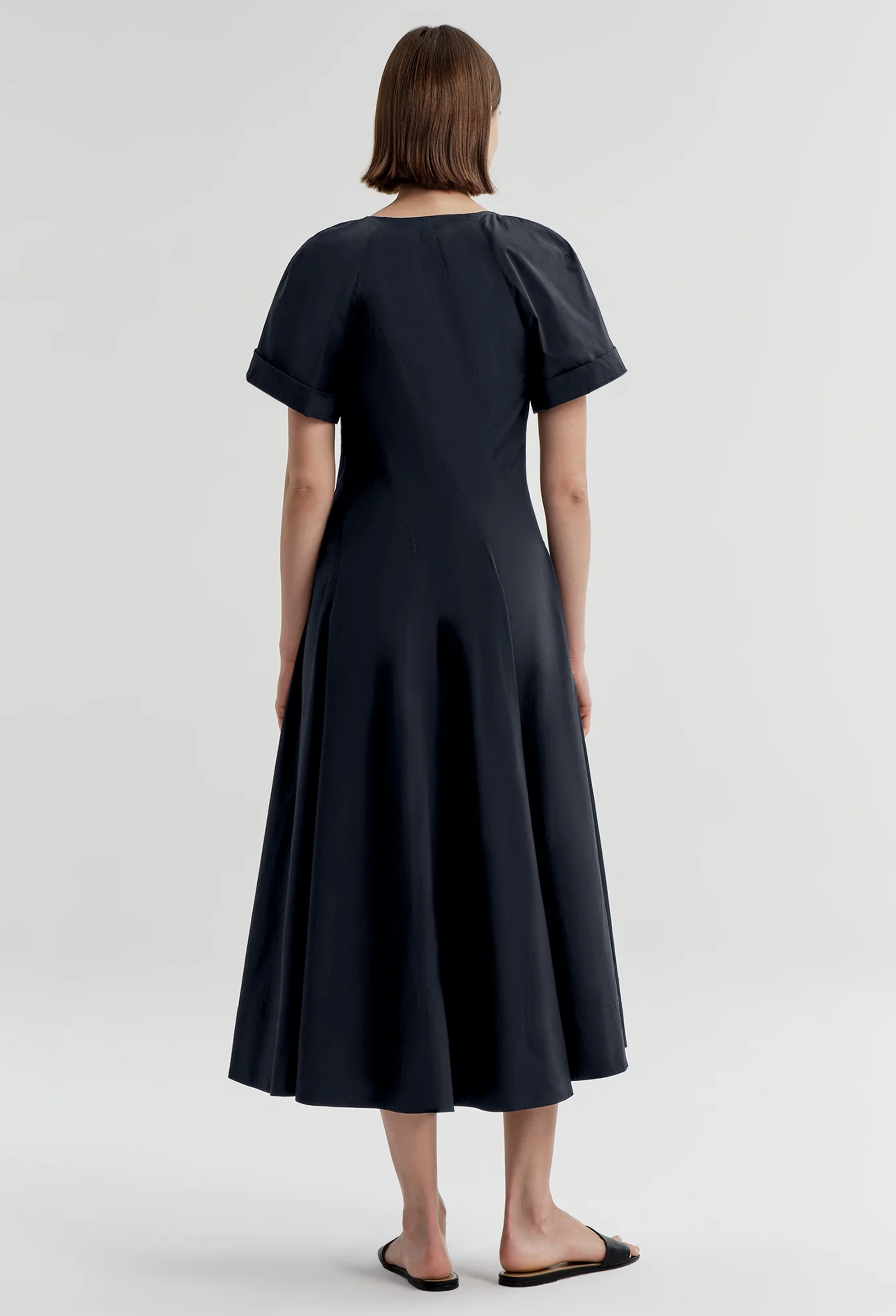 Woman wearing a navy dress on a white background