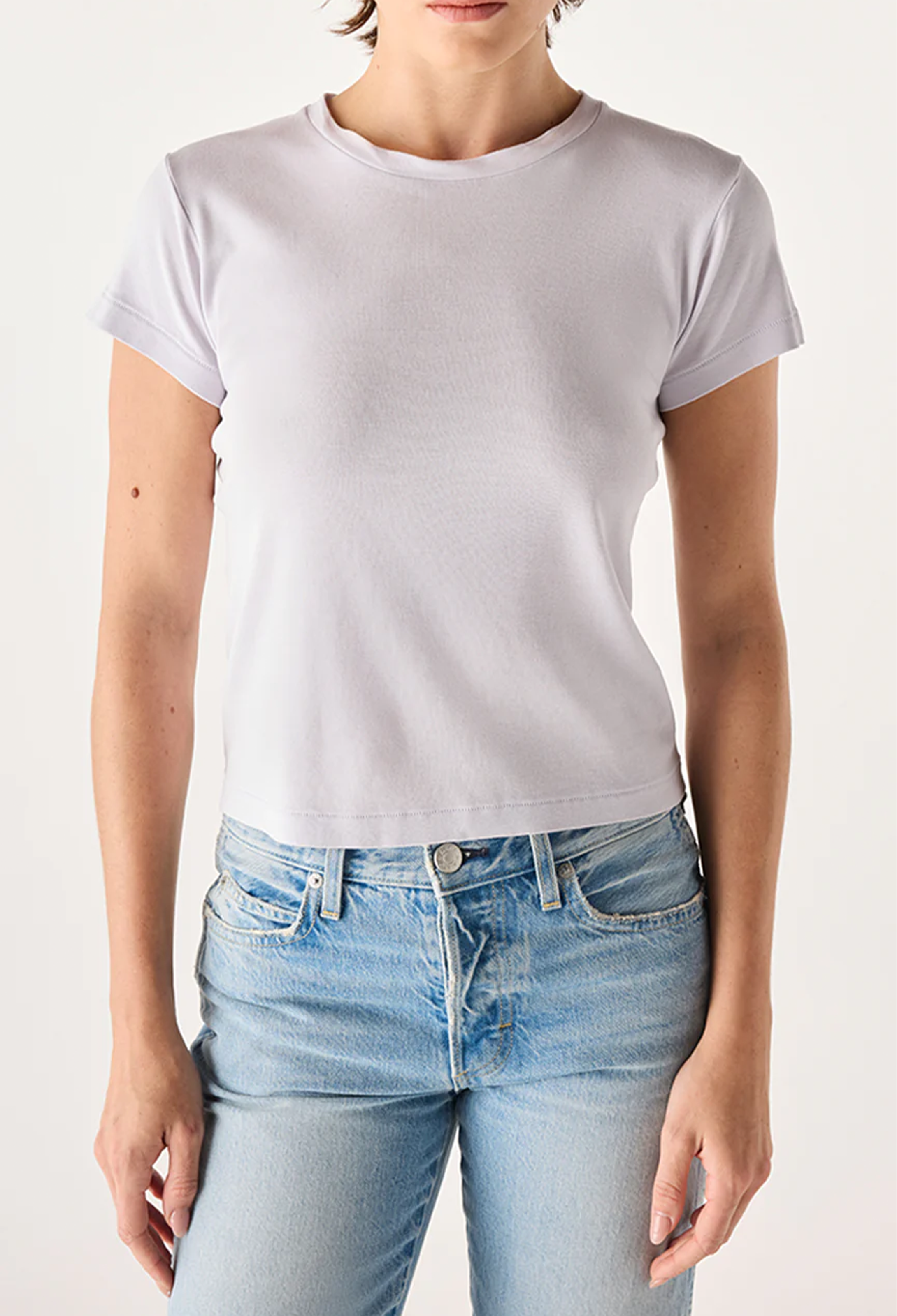 Person wearing a plain light purple t-shirt and light blue jeans on a white background