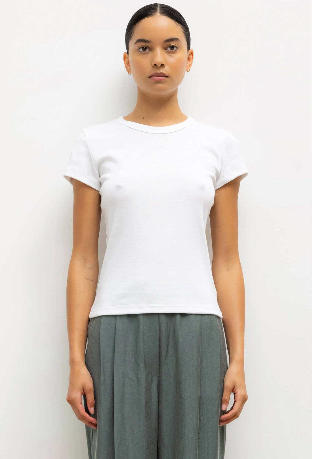Person wearing a plain white t-shirt and gray pants on a white background