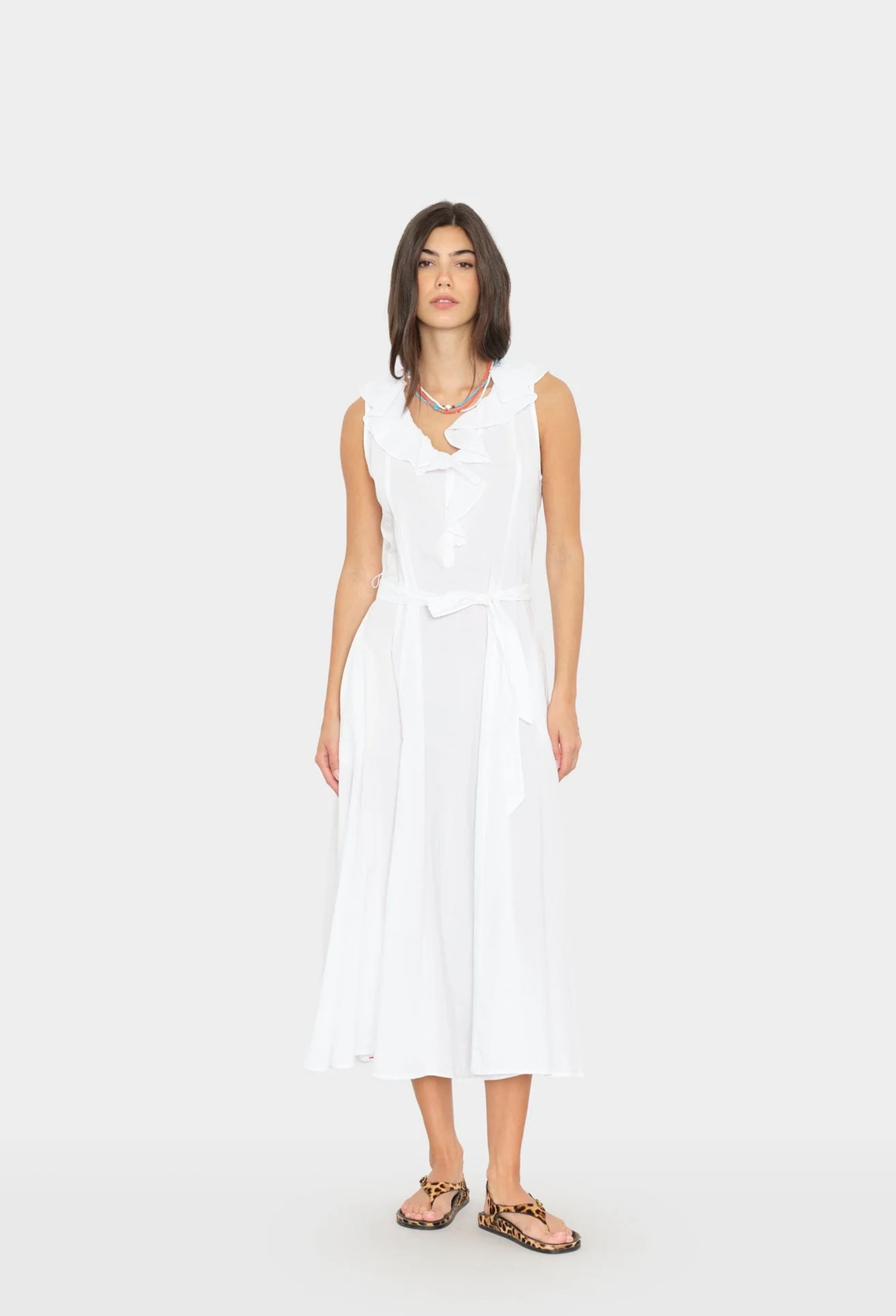 Woman wearing a white sleeveless dress on a white background