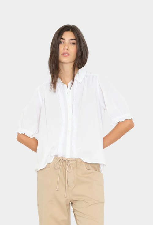Woman wearing a white shirt and beige pants on a white background