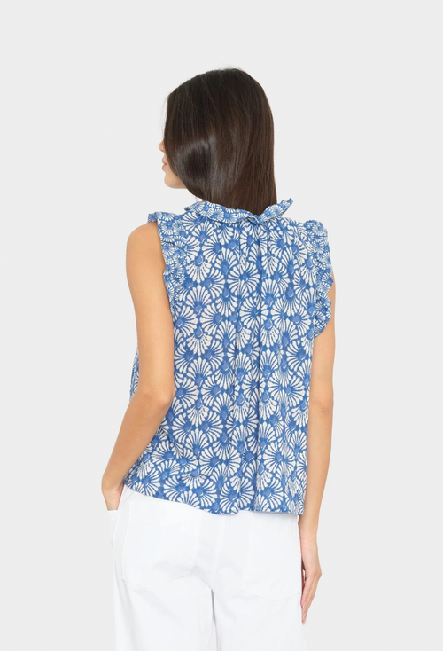 Woman wearing a blue floral sleeveless top on a white background