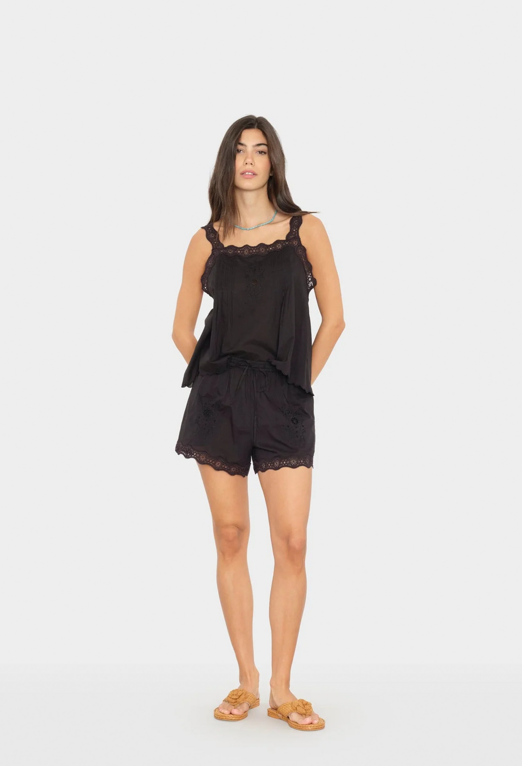 Woman wearing a black lace top and shorts on a white background