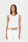 Woman wearing a white sleeveless top and white pants with a brown belt on a white background