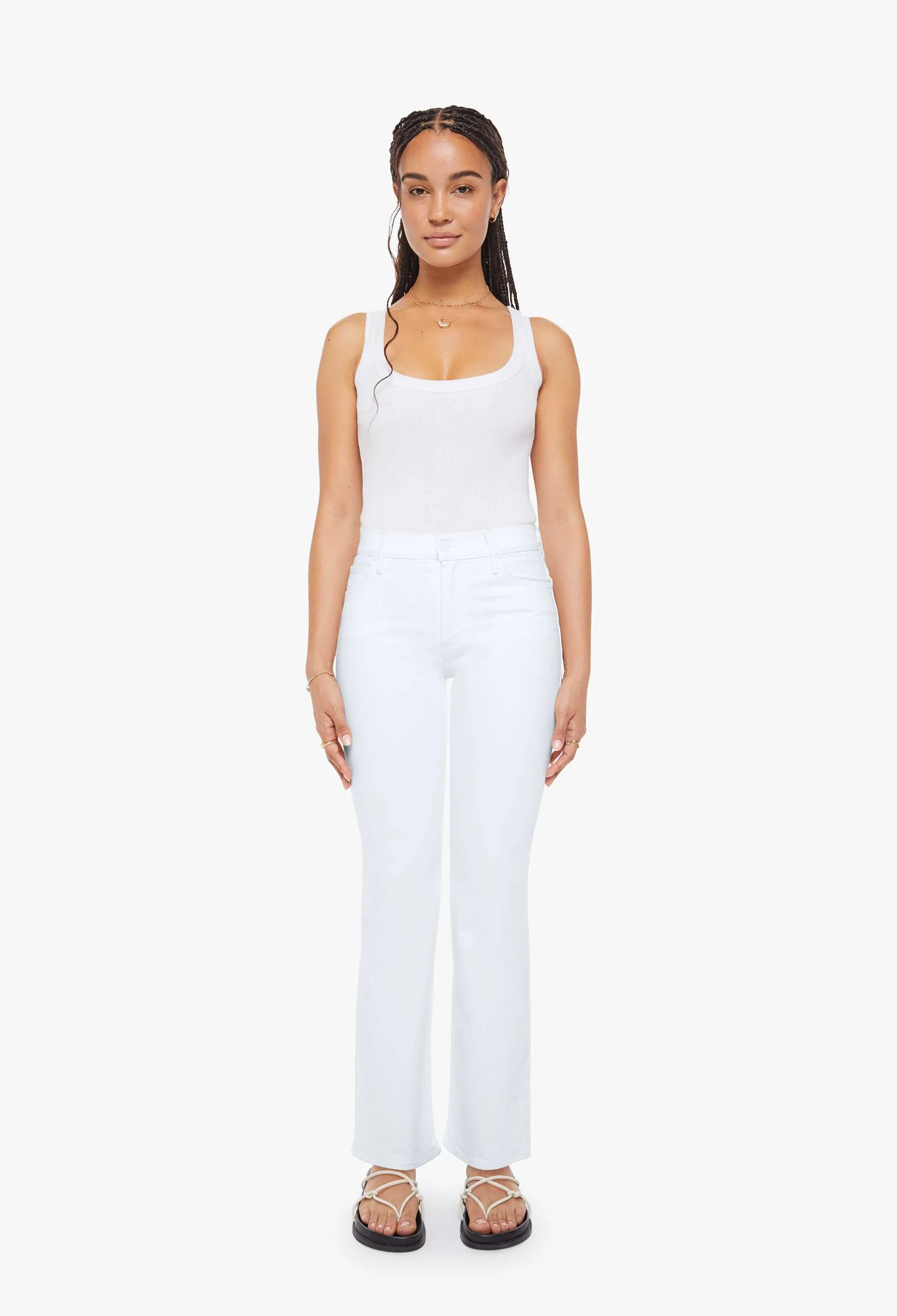 Woman wearing a white sleeveless top and pants on a white background