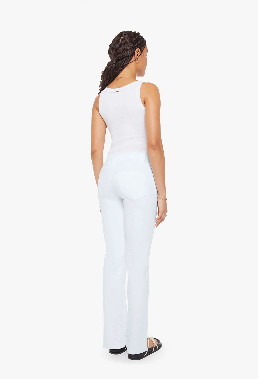 Woman wearing a white sleeveless top and pants on a white background