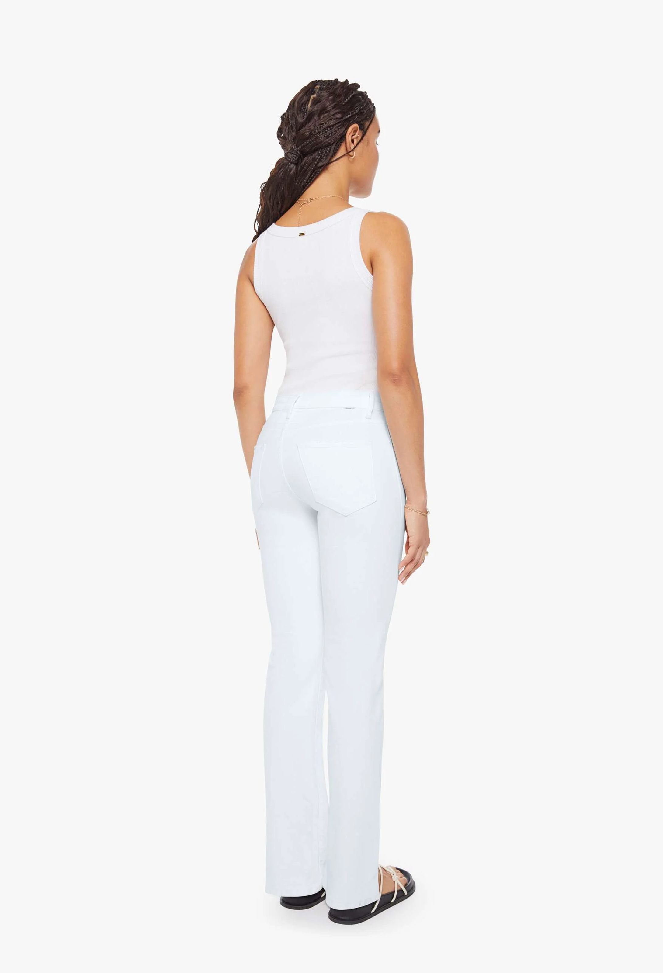 Woman wearing a white sleeveless top and pants on a white background
