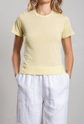 Person wearing a yellow t-shirt and white pants on a plain background