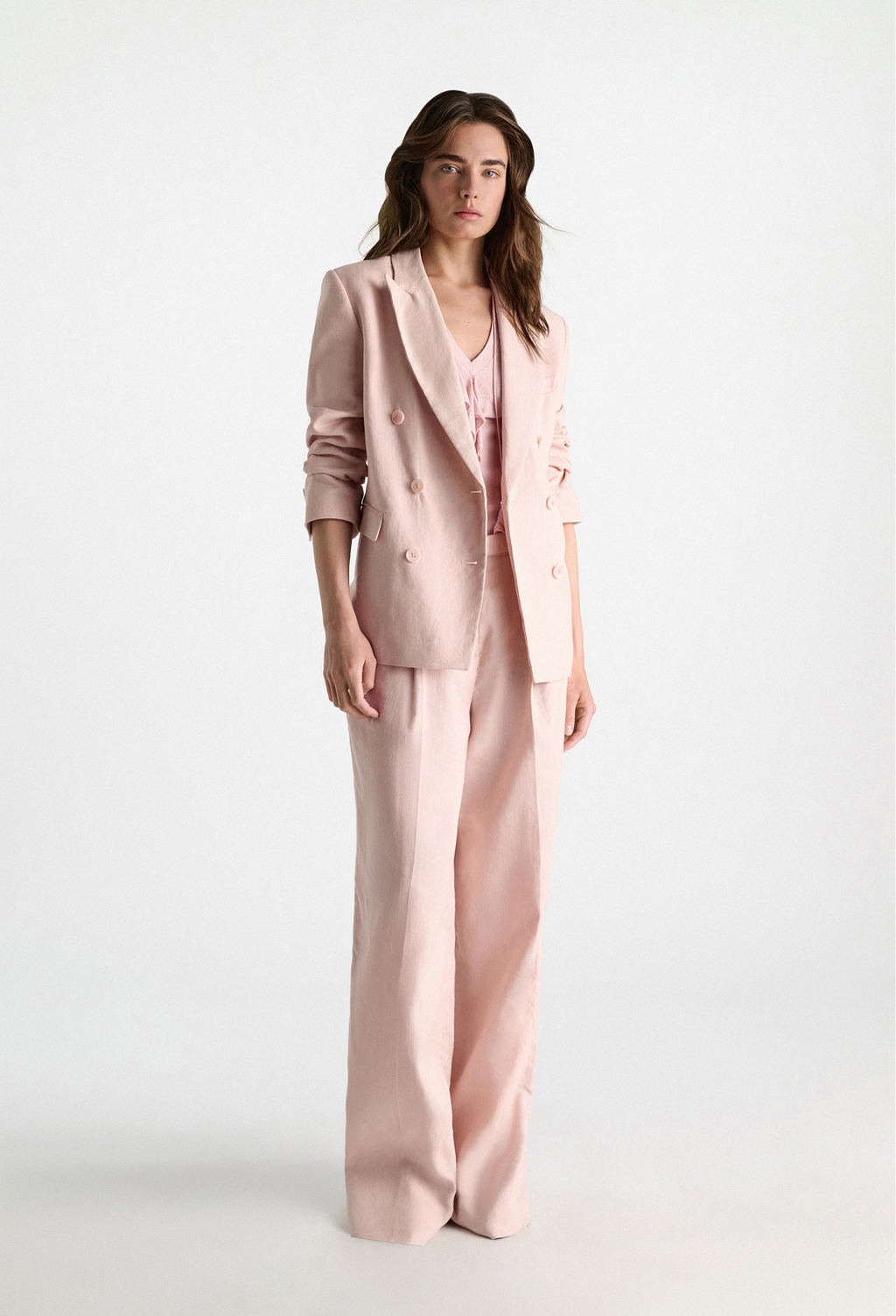 Woman wearing a pink suit on a white background