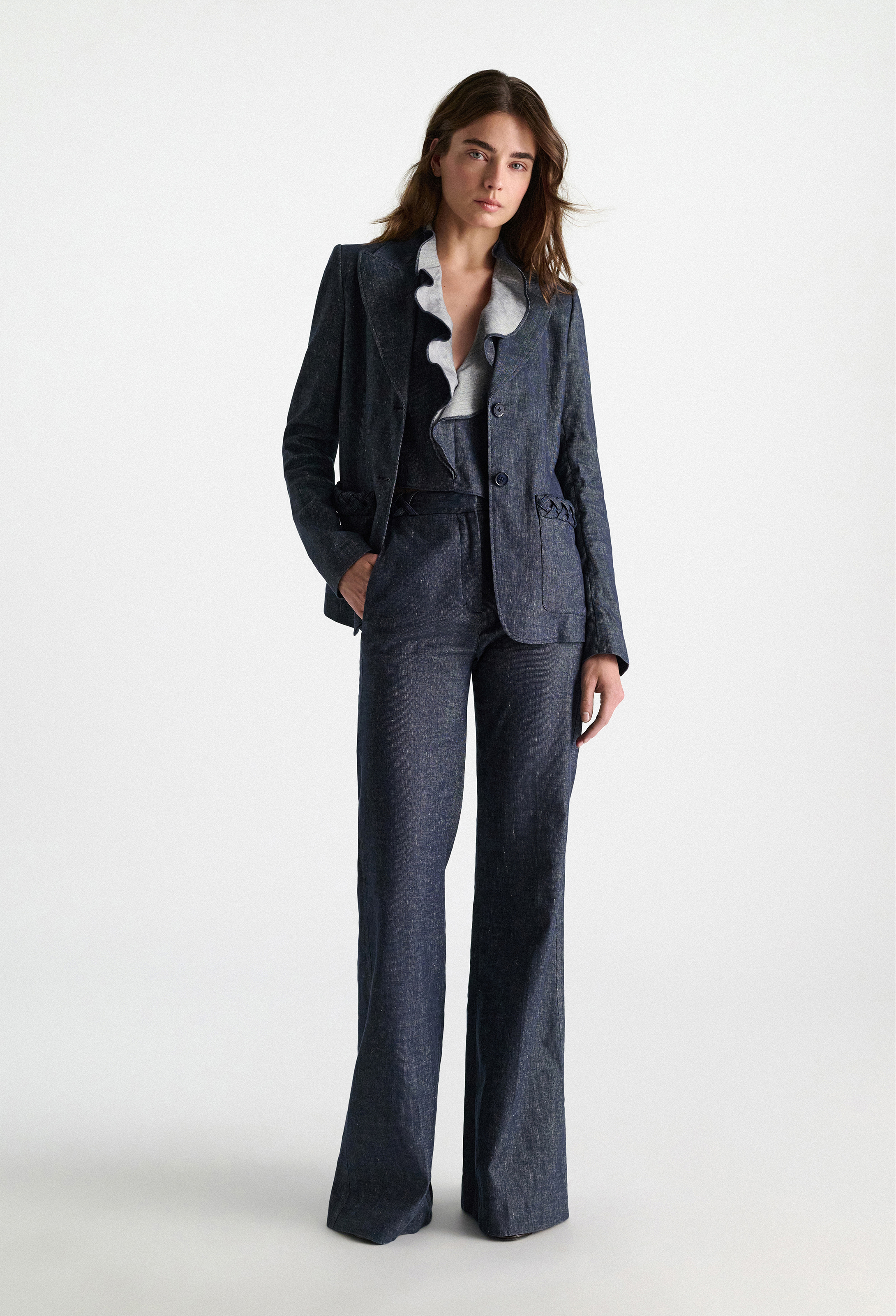 Woman wearing a blue suit with a white shirt on a white background
