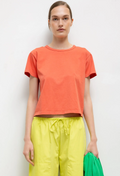 Person wearing an orange t-shirt and yellow pants against a white background