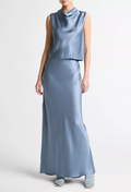Woman wearing a light blue sleeveless top and long skirt set on a white background