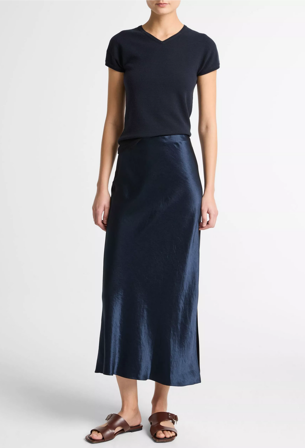 Woman wearing a blue top and long blue skirt on a white background
