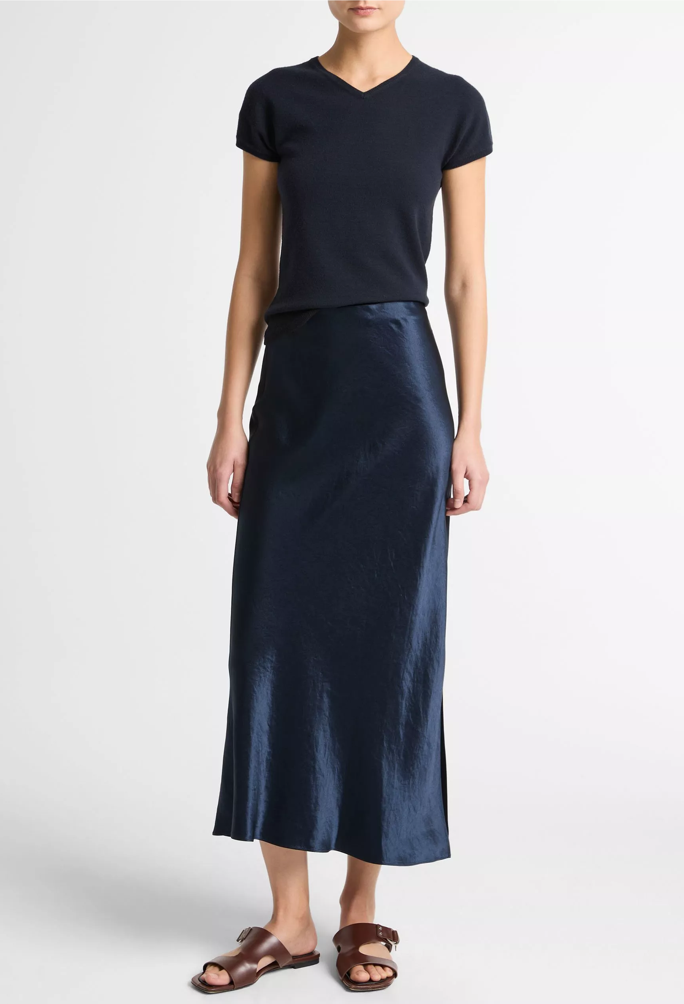 Woman wearing a blue top and long blue skirt on a white background