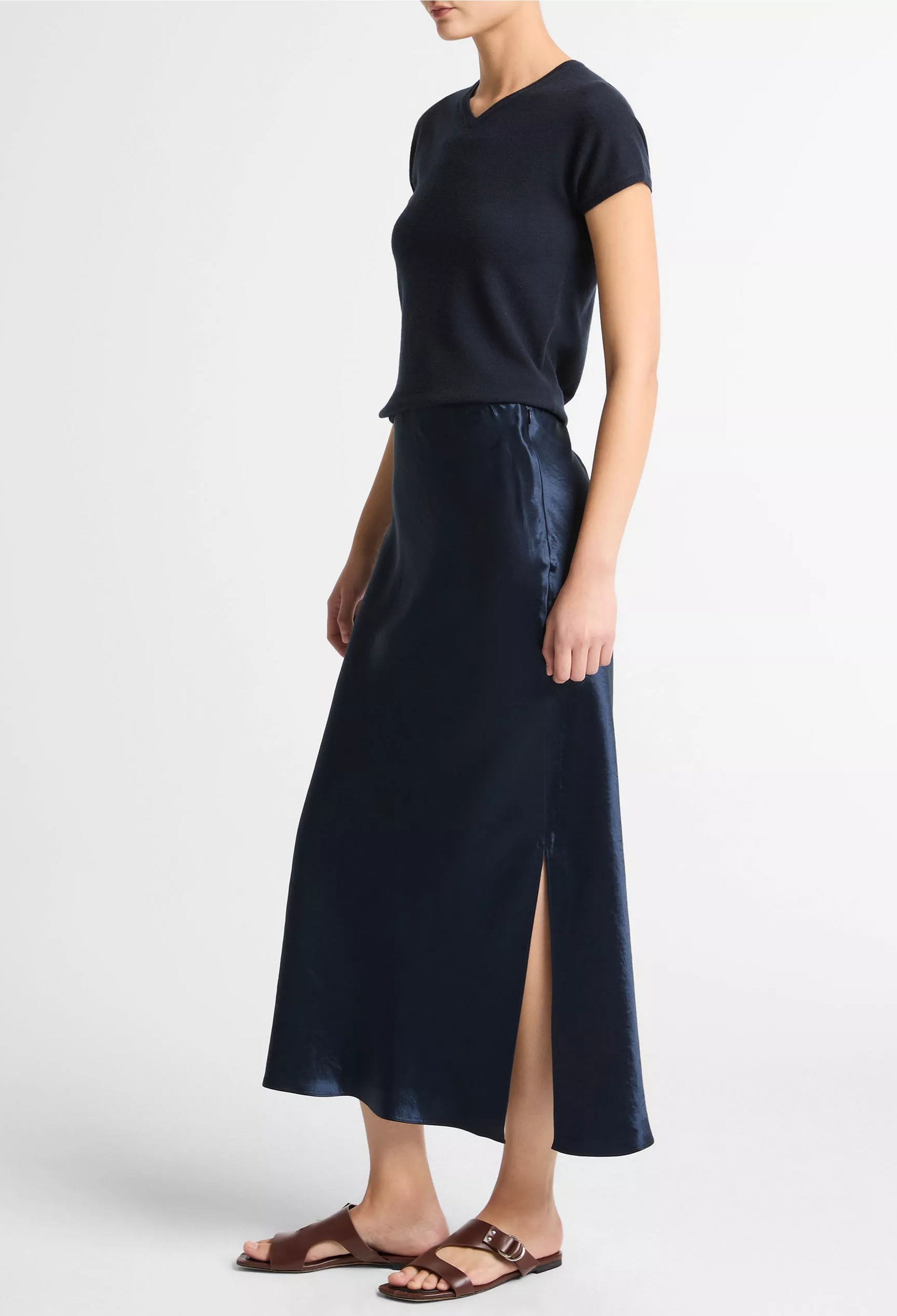 Woman wearing a blue top and long blue skirt on a white background
